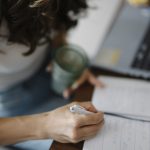 A person writing in a notebook at a tidy desk