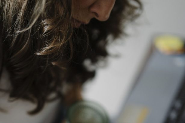 A person writing in a notebook at a tidy desk