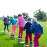 Children playing and exercising outdoors on a school field