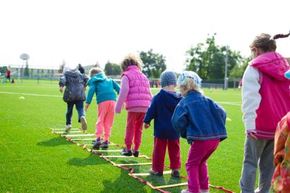 Children playing and exercising outdoors on a school field