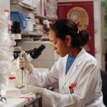 Researcher using pipettes in a laboratory