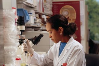 Researcher using pipettes in a laboratory