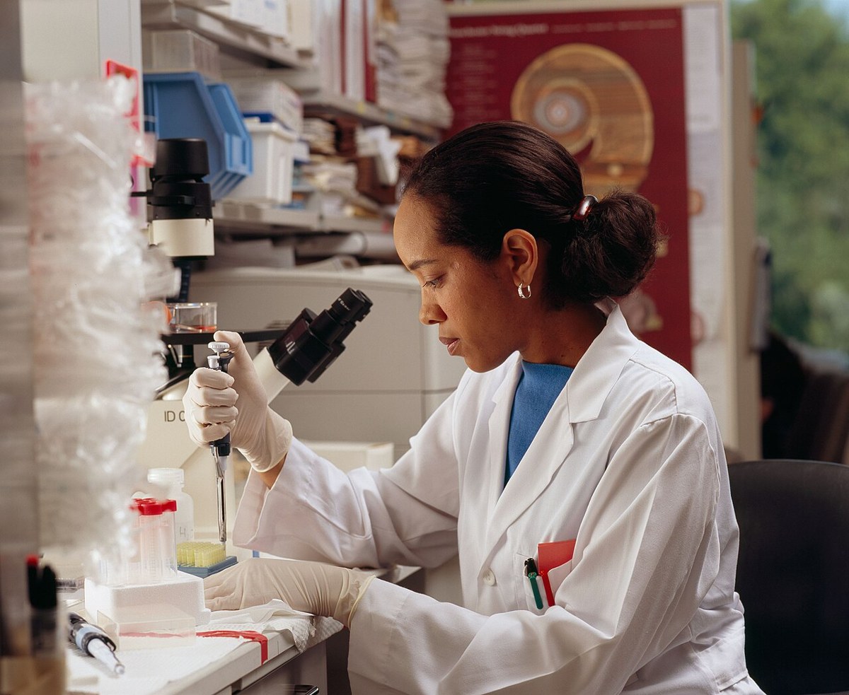 Researcher using pipettes in a laboratory