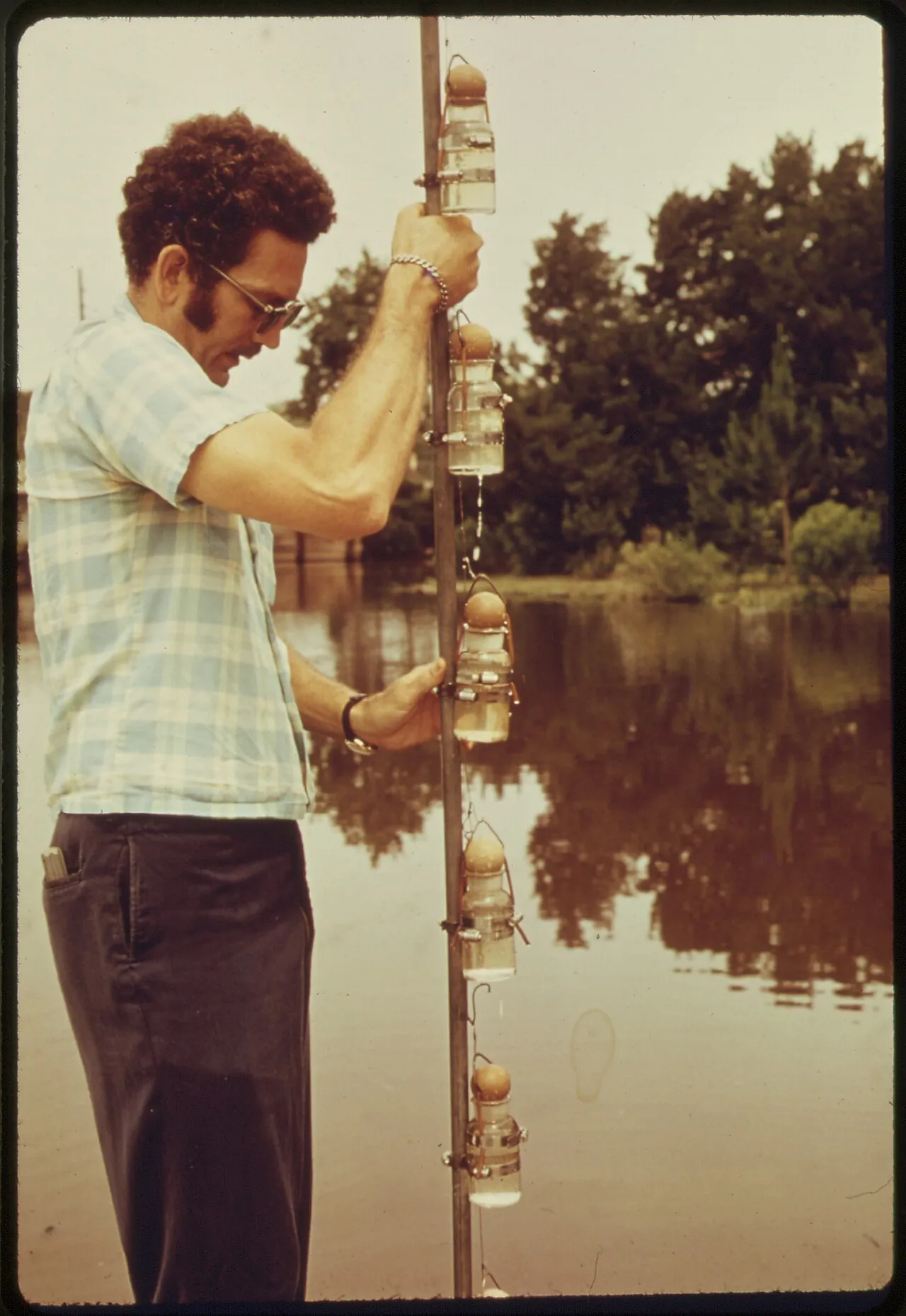 A scientist taking water samples beside a research vessel