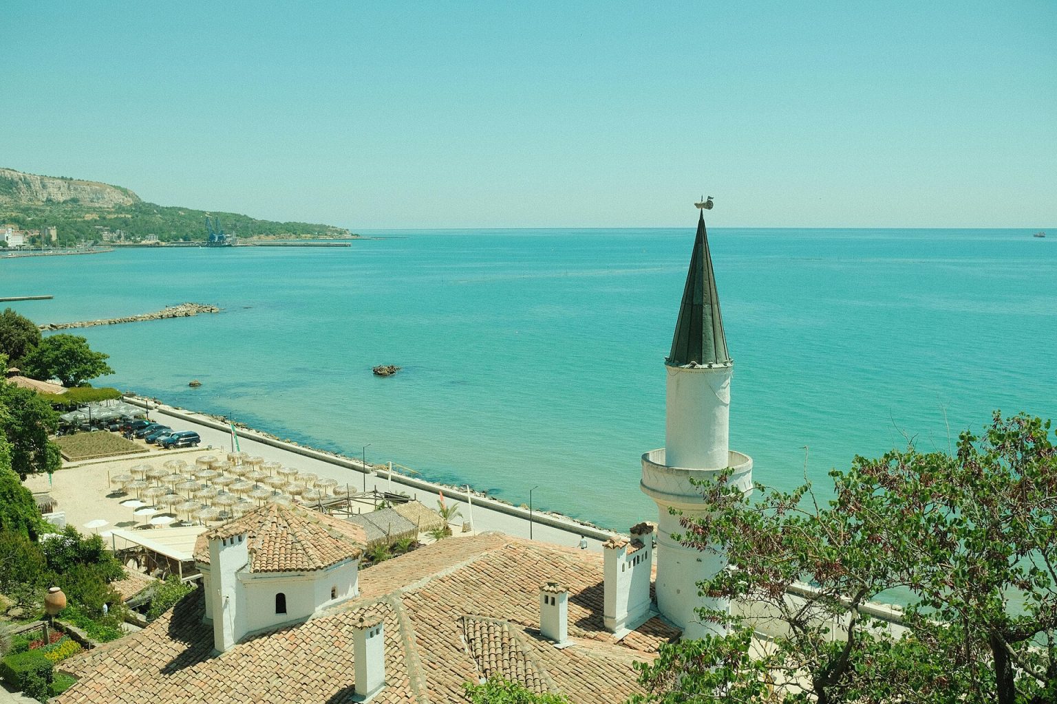 A dry Mediterranean coastline with parched land above a blue sea.