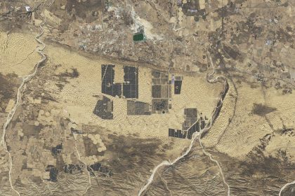 Rows of solar panels in a desert landscape under a clear sky